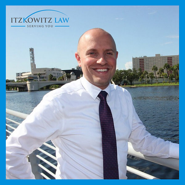 Photo of attorney Adam Itzkowitz outside with firm logo in upper left corner
